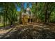 Charming house with a wooden staircase and an elevated foundation surrounded by lush trees at 2468 Marina Rd, Wadmalaw Island, SC 29487