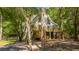 Stunning A-frame house with a large deck surrounded by mature trees and lush greenery at 2468 Marina Rd, Wadmalaw Island, SC 29487