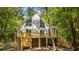 Stunning A-frame house with a large deck surrounded by mature trees and lush greenery at 2468 Marina Rd, Wadmalaw Island, SC 29487
