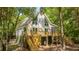 Stunning A-frame house with a large deck surrounded by mature trees and lush greenery at 2468 Marina Rd, Wadmalaw Island, SC 29487