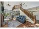 Bright living room showcases a staircase to the loft, white brick accents, and seamless transition to dining area at 2468 Marina Rd, Wadmalaw Island, SC 29487