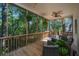 Inviting outdoor living space with comfortable furniture and a ceiling fan overlooking scenic foliage at 2468 Marina Rd, Wadmalaw Island, SC 29487