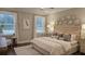 Bright bedroom with large windows, patterned rug, and upholstered headboard with decorative wall hangings at 260 Huguenot Trl, Huger, SC 29450