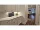 Butler's pantry with white cabinets, quartz counters, and access to main living area at 260 Huguenot Trl, Huger, SC 29450