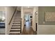 Hallway with hardwood floors, leading to stairs and a sunlit living area at 260 Huguenot Trl, Huger, SC 29450