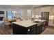 Island kitchen with stainless steel appliances, white cabinetry, and open dining area at 260 Huguenot Trl, Huger, SC 29450