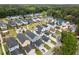 An aerial view of a neighborhood showcasing colorful homes with sidewalks and green spaces surrounded by lush trees at 2747 Calico Bass Ln, Johns Island, SC 29455