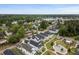 Aerial view of a quaint neighborhood near a lake, featuring colorful homes, sidewalks, and lush green spaces at 2747 Calico Bass Ln, Johns Island, SC 29455