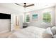 Bright bedroom boasting a ceiling fan, two windows, and en suite bathroom access at 2747 Calico Bass Ln, Johns Island, SC 29455