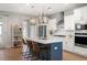Modern kitchen with white cabinets, stainless steel appliances, an island with bar seating, and hardwood floors at 2747 Calico Bass Ln, Johns Island, SC 29455