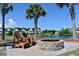 Inviting lakeside setting with an outdoor fire pit and Adirondack chairs, perfect for relaxation and enjoying the view at 2747 Calico Bass Ln, Johns Island, SC 29455