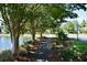 Scenic view of a paved walking path shaded by mature trees along a community lake, enhancing outdoor living and neighborhood charm at 2747 Calico Bass Ln, Johns Island, SC 29455