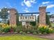 Entrance to Hewing Farms with a brick sign and colorful landscaping at 277 Fiddleback Dr, Summerville, SC 29486