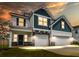 Exterior elevation of a two-story home with a three car garage and professionally landscaped front yard at 277 Fiddleback Dr, Summerville, SC 29486