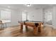 A bright game room features a stylish pool table with views to another room from multiple windows at 277 Fiddleback Dr, Summerville, SC 29486