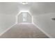Finished attic space with neutral carpet, white walls, and a centered window at 306 Mizell Rd, Dorchester, SC 29437
