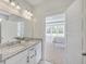 Double sink bathroom vanity featuring granite countertops and white cabinets, leading into the bedroom at 306 Mizell Rd, Dorchester, SC 29437