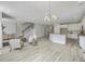 Open-concept living room with wood floors, staircase, and view to kitchen with white cabinets at 306 Mizell Rd, Dorchester, SC 29437