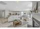 Open-concept living room with wood floors, fireplace, and view to kitchen with white cabinets and island at 306 Mizell Rd, Dorchester, SC 29437