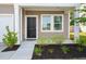 Close up view of front entry with tidy landscaping, a black front door, and sidelight windows at 309 Sedona Dr, Summerville, SC 29486