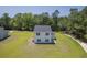 Elevated view of a newly constructed house featuring a generous green space and a forest backdrop at 310 Mizell Rd, Dorchester, SC 29437