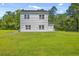 Backyard featuring a well-maintained lawn, green foliage, and two-story siding home at 310 Mizell Rd, Dorchester, SC 29437