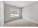 Bright bedroom featuring neutral walls, carpet flooring, and a window with a view of the outdoors at 310 Mizell Rd, Dorchester, SC 29437