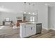Open-concept kitchen features a large island, stainless steel dishwasher, and views of the living room fireplace at 310 Mizell Rd, Dorchester, SC 29437