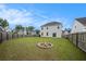 Large backyard featuring a fire pit, a lush lawn, and a charming two-story home at 313 Catawba Branch Way, Moncks Corner, SC 29461