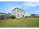 Large fenced backyard with a lush lawn and a charming two-story home in the background at 313 Catawba Branch Way, Moncks Corner, SC 29461
