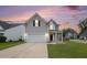 Charming two-story home with gray siding, attached garage, and well-maintained front yard at 313 Catawba Branch Way, Moncks Corner, SC 29461