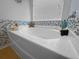 Close-up of a bathroom tub with stylish tile work and beach-themed decorations near the window at 346 Cicadas Song, Moncks Corner, SC 29461