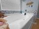 Detail of a bright tub with decorations, set against a window and blue-accented tiled wall at 346 Cicadas Song, Moncks Corner, SC 29461