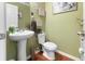 Small bathroom with pedestal sink, toilet, and decorative wall art at 346 Cicadas Song, Moncks Corner, SC 29461