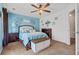 Comfortable bedroom features beautiful blue accent wall, decorative floral hangings, ceiling fan and plush carpet at 346 Cicadas Song, Moncks Corner, SC 29461