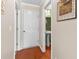 Hallway with wooden floors leading to a bathroom and a closed door at 346 Cicadas Song, Moncks Corner, SC 29461