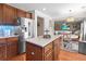 Kitchen with stainless steel refrigerator and island, open to the dining area and living room at 346 Cicadas Song, Moncks Corner, SC 29461
