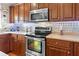 Cozy kitchen featuring stainless steel appliances, wood cabinets, and decorative backsplash at 346 Cicadas Song, Moncks Corner, SC 29461