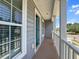 The gray-sided home boasts a charming porch with white columns and wood-look flooring at 346 Cicadas Song, Moncks Corner, SC 29461