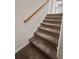 Carpeted stairway with a wooden handrail and white trim offers safe passage at 346 Cicadas Song, Moncks Corner, SC 29461