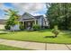 Landscaped home exterior featuring a lush lawn, mature trees, and a charming front porch for curb appeal at 3639 Pimmit Pl, Ladson, SC 29456