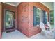 Cozy front porch with classic brick accents, white chairs, and neat landscaping for relaxing curb appeal at 3639 Pimmit Pl, Ladson, SC 29456