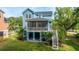 Charming blue home with a screened porch, manicured landscaping, and inviting staircase to the yard at 3711 Tip Ln, Mount Pleasant, SC 29466