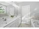 Bathroom vanity with double sinks, white cabinetry, large mirror, and natural light from the window at 3711 Tip Ln, Mount Pleasant, SC 29466