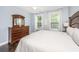 Cozy bedroom featuring hardwood floors, dresser with mirror, and natural light from the windows at 3711 Tip Ln, Mount Pleasant, SC 29466