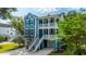 Charming blue two-story home featuring double balconies, a well-manicured lawn, and a paved driveway at 3711 Tip Ln, Mount Pleasant, SC 29466