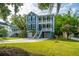 Charming two-story blue home with double porches, landscaped yard, and two-car garage at 3711 Tip Ln, Mount Pleasant, SC 29466