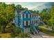 Charming two-story blue home featuring a double porch, lush landscaping, and a garage at 3711 Tip Ln, Mount Pleasant, SC 29466