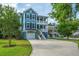 Two-story blue home with double porches, garage, and lawn surrounded by mature trees and landscaping at 3711 Tip Ln, Mount Pleasant, SC 29466