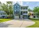 Attractive blue two-story home with double porches, attached garage, well maintained lawn, and mature trees at 3711 Tip Ln, Mount Pleasant, SC 29466